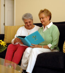 caregiver and elderly reading a book